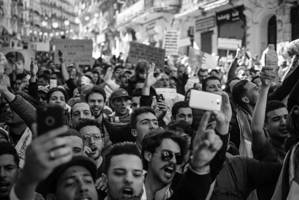 black and white photo of a crowd of people facing the camera. meant to illustrate mass immigration